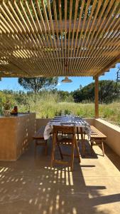 tavolo e panche sotto un pergolato in legno di Braciosa a Coruche