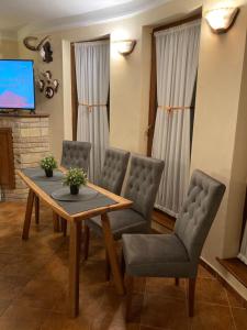 a dining room with a table and chairs and a tv at Aranyhegyi Vendégház in Telkibánya