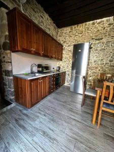 a kitchen with wooden cabinets and a stainless steel refrigerator at Marias House in Kritinía