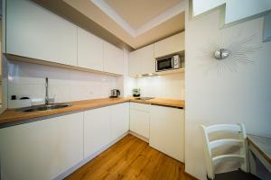 a kitchen with white cabinets and a sink at Flexible SelfCheckIns 172 - Zagreb - Center - New in Zagreb