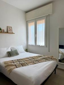 a large white bed in a room with a window at A due passi dal mare - OpenSpace in Porto Garibaldi
