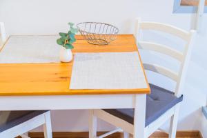 a white table and chairs with a wooden table and a plant at Flexible SelfCheckIns 172 - Zagreb - Center - New in Zagreb