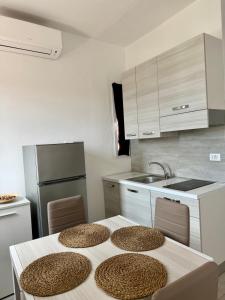 a kitchen with a table with two chairs and a refrigerator at A due passi dal mare - OpenSpace in Porto Garibaldi +16 photos