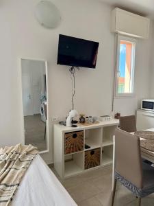 a living room with a television on the wall at A due passi dal mare - OpenSpace in Porto Garibaldi