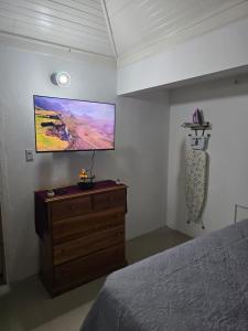 a bedroom with a bed and a flat screen tv at Sunset 22 by the Airport Apt#6 in Montego Bay