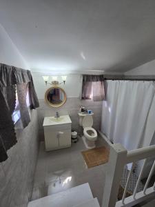 a small bathroom with a toilet and a sink at Sunset 22 by the Airport Apt#6 in Montego Bay +28 photos