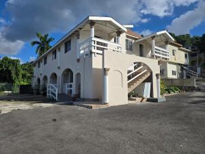 a large white building with a staircase on it at Sunset 22 by the Airport Apt#6 in Montego Bay