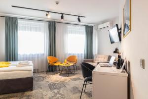 a hotel room with a bed and a couch and a table at Hotel Nafta Krosno in Krosno +103 photos