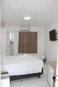 a hospital room with two beds and a shower at Condomínio CTC Araras, Caldas Novas - VPC in Caldas Novas