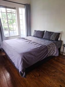 a large bed in a bedroom with a large window at Charming Loft-Style Appartment in Sandton
