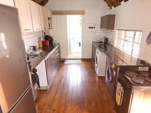 a kitchen with a refrigerator and a wooden floor at Charming Loft-Style Appartment in Sandton