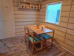 a dining room with a wooden table and chairs at Mobilhome confortable in La Celle-sous-Gouzon