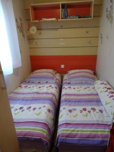 two beds sitting next to each other in a room at Mobilhome confortable in La Celle-sous-Gouzon