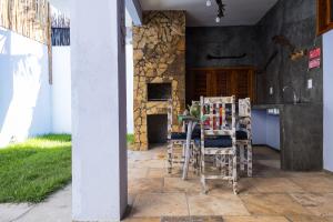 a kitchen with a table and chairs and a stone wall at Casa Massima Preá in Prea