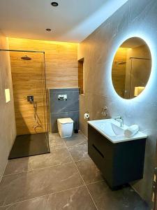 a bathroom with a sink and a toilet and a mirror at Seaside Escape in St Paul's Bay