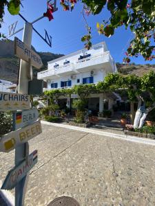 a street sign in front of a white building at Gigilos in Agia Roumeli