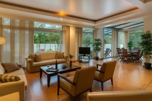 una sala de estar con un sofá y una mesa en Hera's Resort with Private Pool and Lush Garden, en Sani Beach