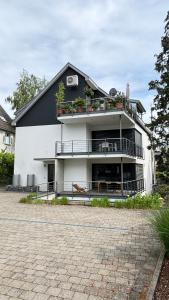 a large white building with a balcony and tables at LAKE Loft Flow in Überlingen