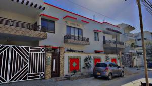a car parked in front of a house at Amada Family Guest House in Karachi