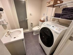 東京にある眺望抜群 高層階 錦糸町駅徒歩5分【浅草,秋葉原,新宿,成田,羽田アクセス】プロジェクタWiFi完備の洗面台と洗濯機を備えたバスルーム