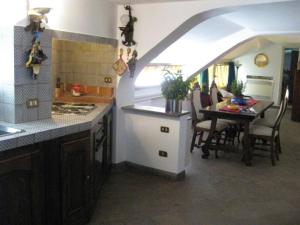 una cucina e una sala da pranzo con tavolo e sedie di La Barca sul Mare a Letoianni