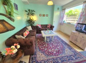 ein Wohnzimmer mit Sofa und Tisch in der Unterkunft Bungalow Texel near beach and city centre in De Koog