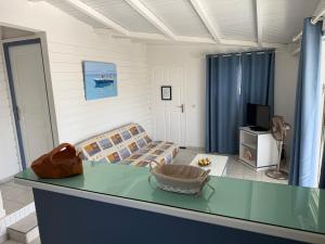 a living room with a table and a couch at LE LAGON BLEU, BUNGALOWS Vue sur MER , 350 m de la plage in Sainte-Anne