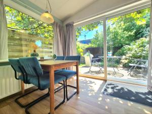 ein Esszimmer mit einem Tisch und einem großen Fenster in der Unterkunft Bungalow Texel near beach and city centre in De Koog