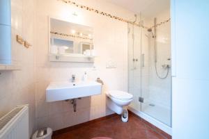 a bathroom with a sink and a toilet and a shower at Haus Oliva Charmante FeWo in Top-Lage mit Balkon und Parkplatz in Bad Kissingen +22 photos