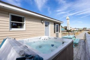 un jacuzzi en la terraza de una casa en Hot Tub Walk to Beach and Dog Friendly, en Kill Devil Hills
