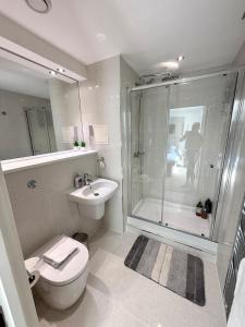 a bathroom with a shower and a toilet and a sink at Luxury Waterfront Apartment With Panoramic View in Cardiff +20 photos