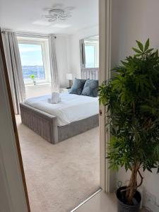 a bedroom with a bed and a large window at Luxury Waterfront Apartment With Panoramic View in Cardiff