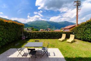 a table and chairs with a view of mountains at Lario10 by Quokka 360 - Garden and Lake View in Abbadia Lariana
