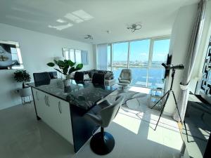 a living room with a table and a large window at Luxury Waterfront Apartment With Panoramic View in Cardiff