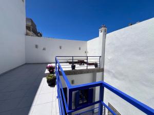 un balcón con un banco y flores en un edificio en Riad de jeanne, en Essaouira