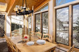 a dining room with a wooden table and some windows at Aspen Alps Apartment #209 in Aspen +3 photos