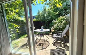 eine Terrassentür mit einem Tisch und Stühlen im Freien in der Unterkunft Bungalow Texel near beach and city centre in De Koog