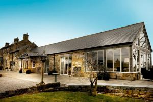 ein altes Steingebäude mit großen Fenstern in der Unterkunft Hillock's Farm Cottage, Luxury in Moorsholm + 34 Fotos