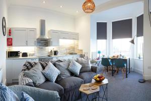 a living room with a couch and a kitchen at Seascape - Fantastic Location with Sea Views! in Scarborough