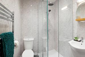 a bathroom with a shower and a toilet and a sink at Seascape - Fantastic Location with Sea Views! in Scarborough +33 photos