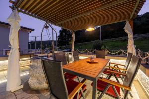 drewniany stół i krzesła na patio w obiekcie Holiday home in Krnica/Istrien 38131 w mieście Krnica