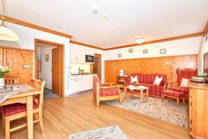 une cuisine et un salon avec une table et des chaises dans l'établissement Ferienwohnung Sophia, à Reit im Winkl