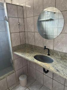 a bathroom with a sink and a mirror and a shower at Lofts Paraíso de Alcobaça in Alcobaça