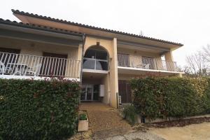 a house with a balcony and a patio at Les Mimosas - App 05 - Appartement Cosy RDC in Cazaubon