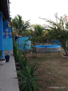 São MamedeEco Pousada Tigipió的蓝色建筑旁边院子里的浴缸