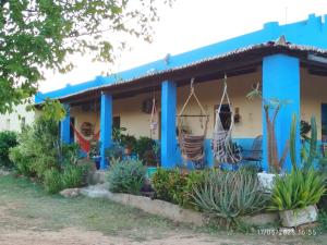 a blue house with hammocks in front of it at Eco Pousada Tigipió in São Mamede
