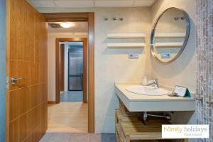 a bathroom with a sink and a mirror at Homity Holidays - Playa Granada - Dos Mares in Motril