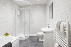 a white bathroom with a shower and a toilet and a sink at The Court Yard Apartment - Fantastic location! in Scarborough