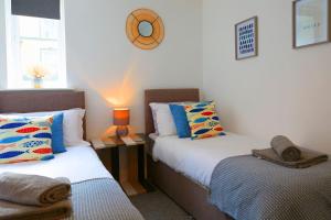 a bedroom with two beds and a table with a lamp at The Court Yard Apartment - Fantastic location! in Scarborough