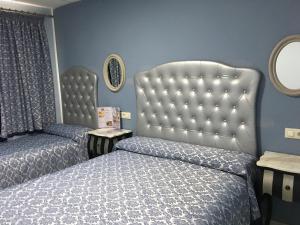 a bedroom with two beds and a tufted headboard at Just Style El Mañico in Peniscola